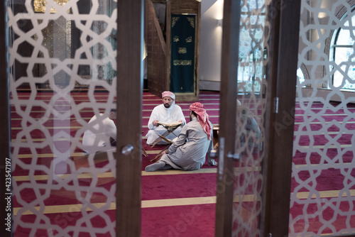 Group of Muslims reading, reciting and remembering Quran during the ramadaninside modern and new mosque
