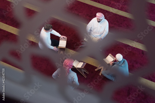 Group of Muslims reading, reciting and remembering  Quran during the ramadaninside modern and new mosque
