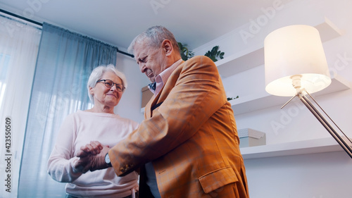 Happy elderly retired couple dancing at home. Birthday, valentines day or anniversary concept. High quality photo
