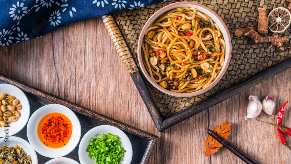 A bowl of Jiangxi Nanchang cuisine Nanchang mixed noodles placed on a wooden table A bowl of Jiangxi Nanchang cuisine Nanchang mixed noodles placed on a wooden table