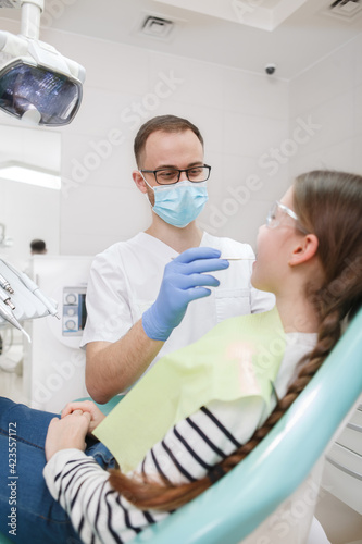 Vertical shot of a male dentist working at his clinic
