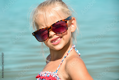 Girl with glasses in the sea smiles without teeth © AliaksandrBS