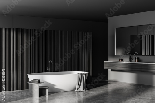 Grey bathroom interior with bathtub and sink with concrete floor