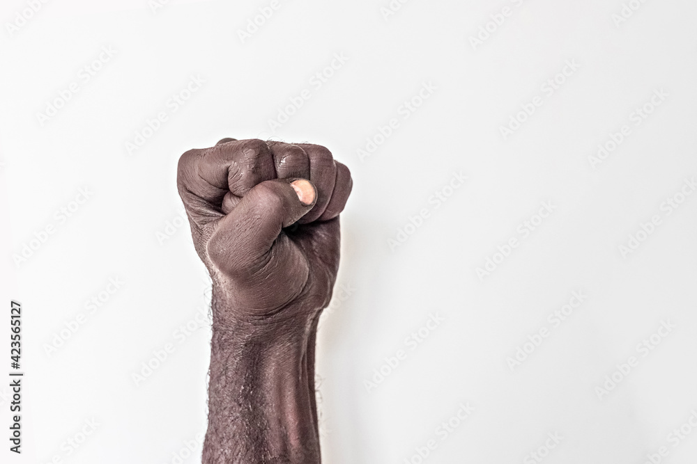 Fototapeta premium Male hand clenched into a fist on a white background. A symbol of the struggle for the rights of blacks in America. Protest against racism. 