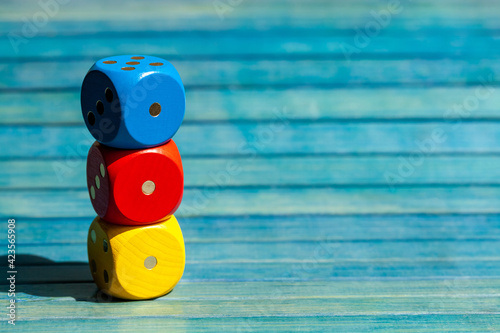 Fotografie Three colorful game dice stack, multi colored dice showing one stacked on top of each other, copy space