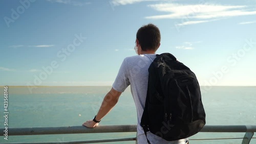 Lone Guy Wearing Face Mask With Backpack Facing Seascape At The Port Of Puerto Ingeniero White In Buenos Aires, Argentina. - Backview photo