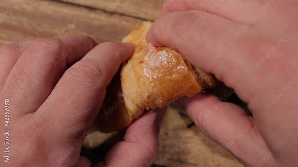 Tear apart a freshly baked croissant in slow motion - studio photography Tear apart a freshly baked croissant in slow motion - studio photography