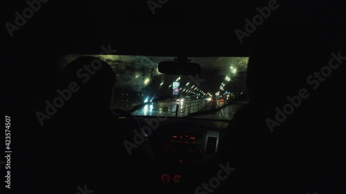 the car drives through the night city in the rain
