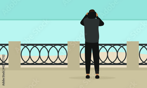 A male character stands on the embankment and puts a hood on his head