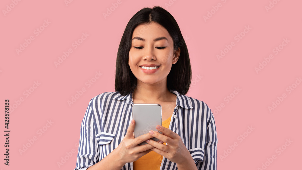 Happy asian young woman using mobile phone at studio Happy asian young woman using mobile phone at studio