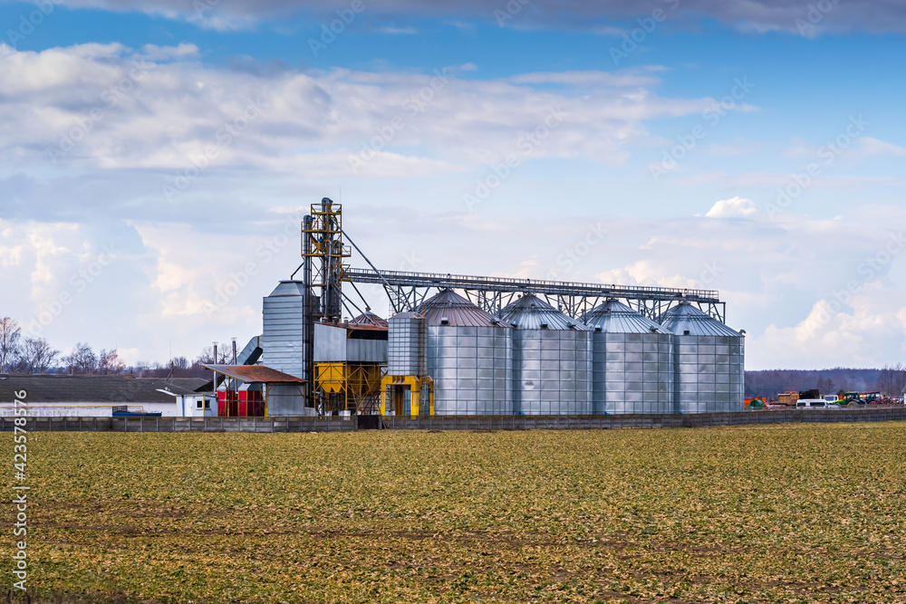 Granary elevator. Silver silos on agro-processing and manufacturing plant for processing drying cleaning and storage of agricultural products, flour, cereals and grain. Granary elevator. Silver silos on agro-processing and manufacturing plant for processing drying cleaning and storage of agricultural products, flour, cereals and grain.