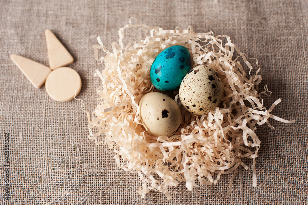 Obraz premium easter eggs in the nest wooden hare icon on a crafting background