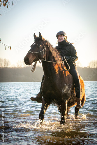 Reiterin mit Pferd im See