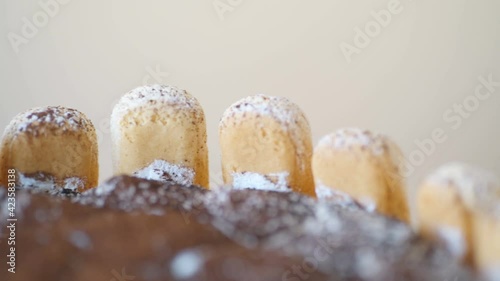 Delicious tiramisu cake on beige background. Tasty dessert side view. Traditional Italian cuisine concept .