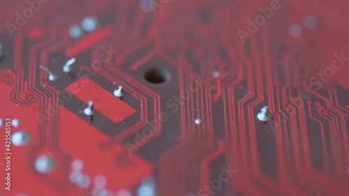 Rotation of a bright red board with chips and microcircuits in slow motion