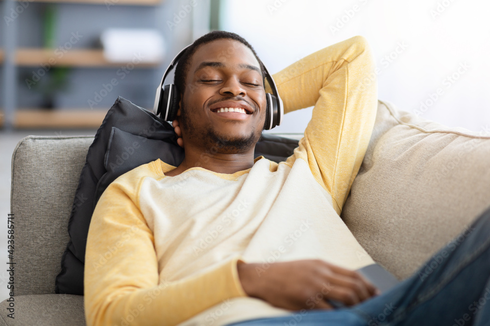 Closeup portrait of happy black guy in wireless headset