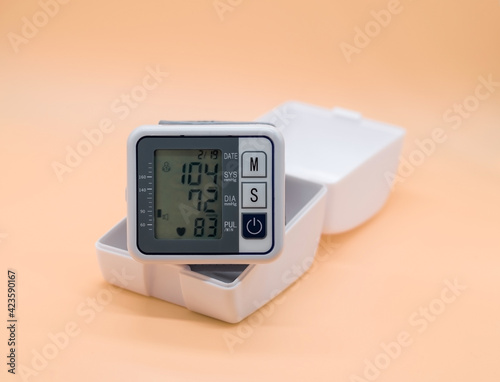 electronic tonometer on the wrist on a beige background