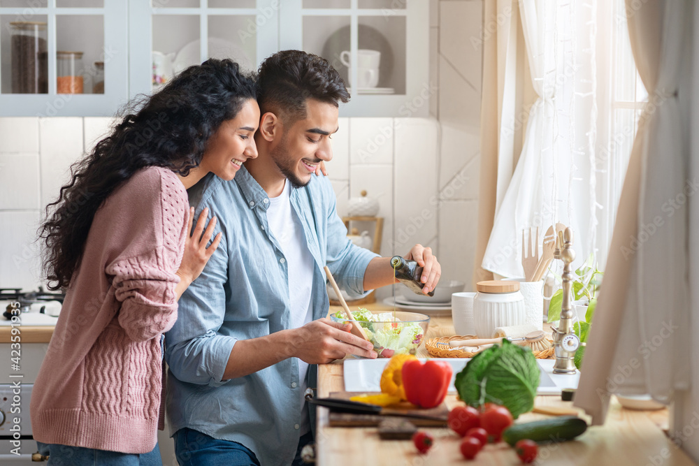 Modern muslim couple cooking healthy food in kitchen at home together Modern muslim couple cooking healthy food in kitchen at home together