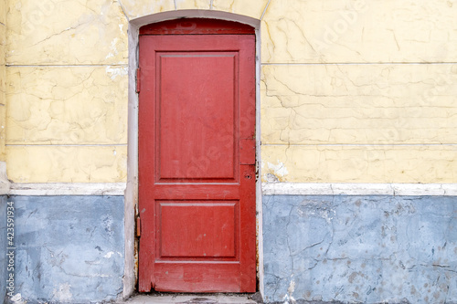 The red wooden door without a lock consists of two sections