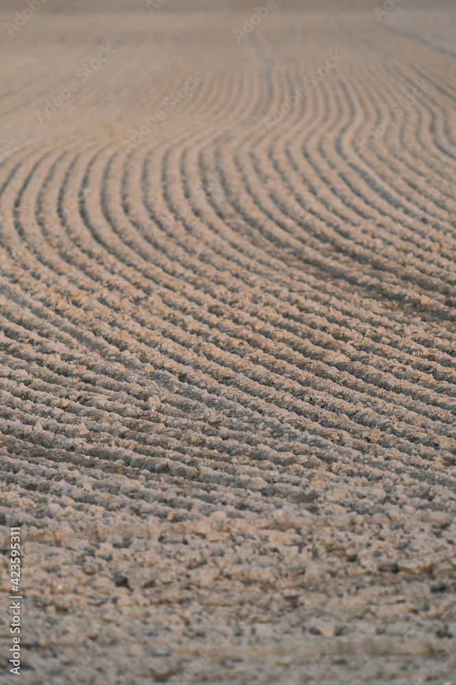 Furrows row pattern in a plowed field at springtime