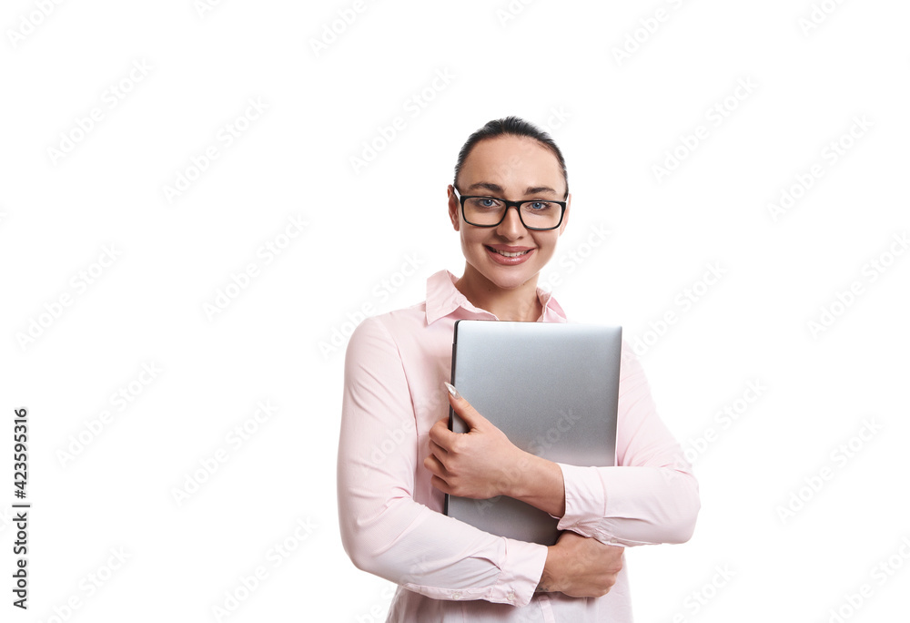 Portrait of a young woman holding a laptop in hands, smiling while posing on white background with copy space Portrait of a young woman holding a laptop in hands, smiling while posing on white background with copy space