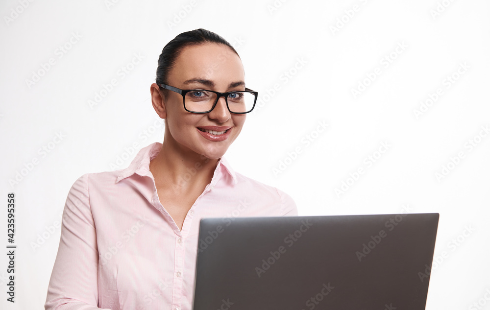 Portrait of a young cheerful woman smiling looking at the camera on a white background with a laptop in her hands Portrait of a young cheerful woman smiling looking at the camera on a white background with a laptop in her hands