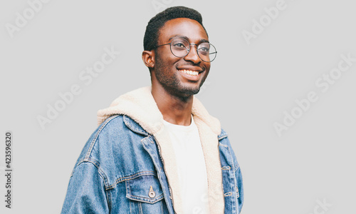 Portrait of happy smiling african man looking away wearing an eyeglasses on a gray background