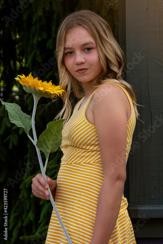 Фотография Vertical outdoor portrait of a beautiful tween girl with long blonde hair wearin