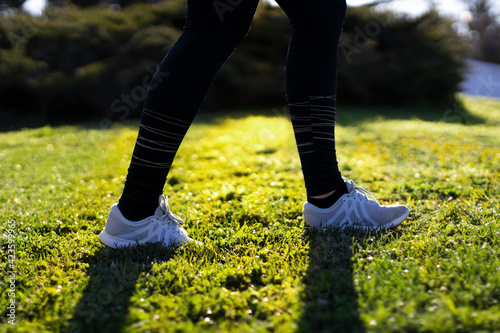 woman runner walking in a grass field in a park at morning.