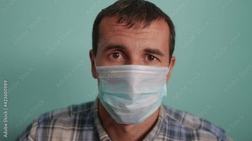 man wear puts on protective mask a indoor portrait. epidemic corona outbreak concept. male 37 years old brunette in blue medical mask lifestyle isolated. Coronavirus disease. dad teamwork self
