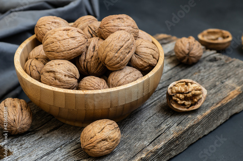Ripe and raw whole big walnut kernel with shell on rustic backdrop. healthy nut food for brain
