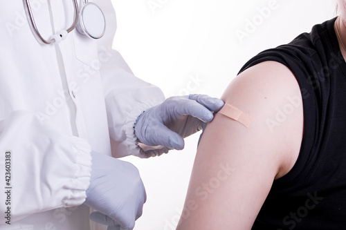 A doctor wearing gloves vaccinates the patient with the vaccine