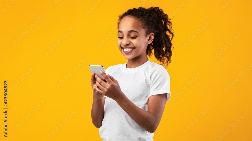 Smiling black girl using mobile phone at studio Smiling black girl using mobile phone at studio