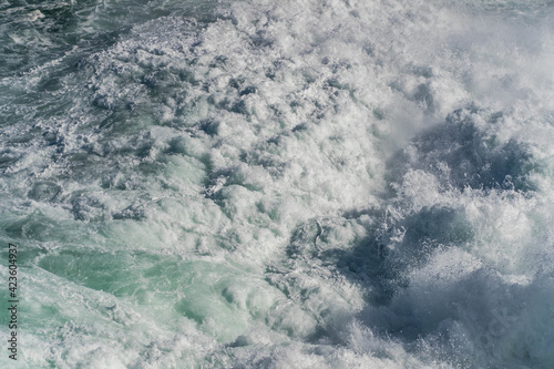 Fototapeta Naklejka Na Ścianę i Meble -  Seawater from a wave as it breaks against a rock, sea foam