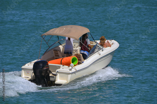 Motor boat powered by a single outboard engine, outfitted with a Bimini top cruising on the Florida Intra-Coastal Waterway off of Miami Beach. © Wimbledon