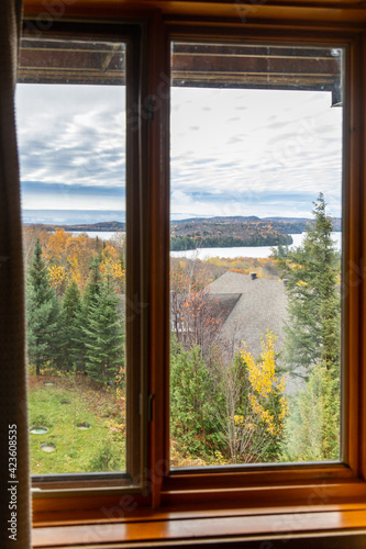 vue de la nature avec ciel ennuagé en automne au travers d'une fenêtre