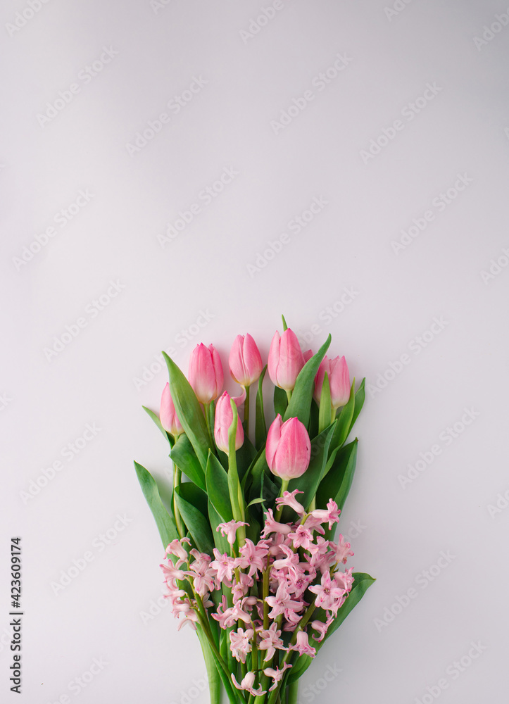 Spring floral arrangement with pink tulips and pink hyacinth on bright background. Minimal concept. Copy space.