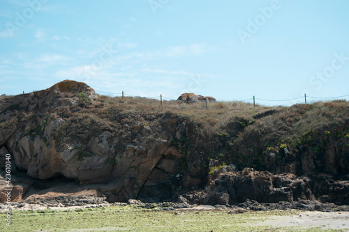 Pequeña montaña en la orilla de la playa con césped en un día soleado