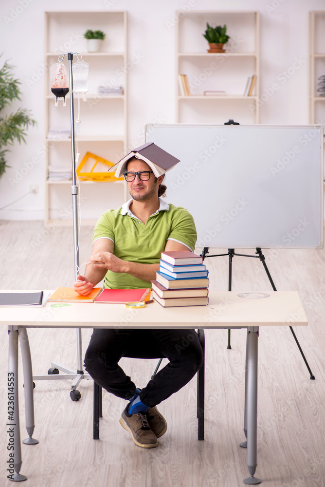 Young sick male teacher student in blood transfusion concept