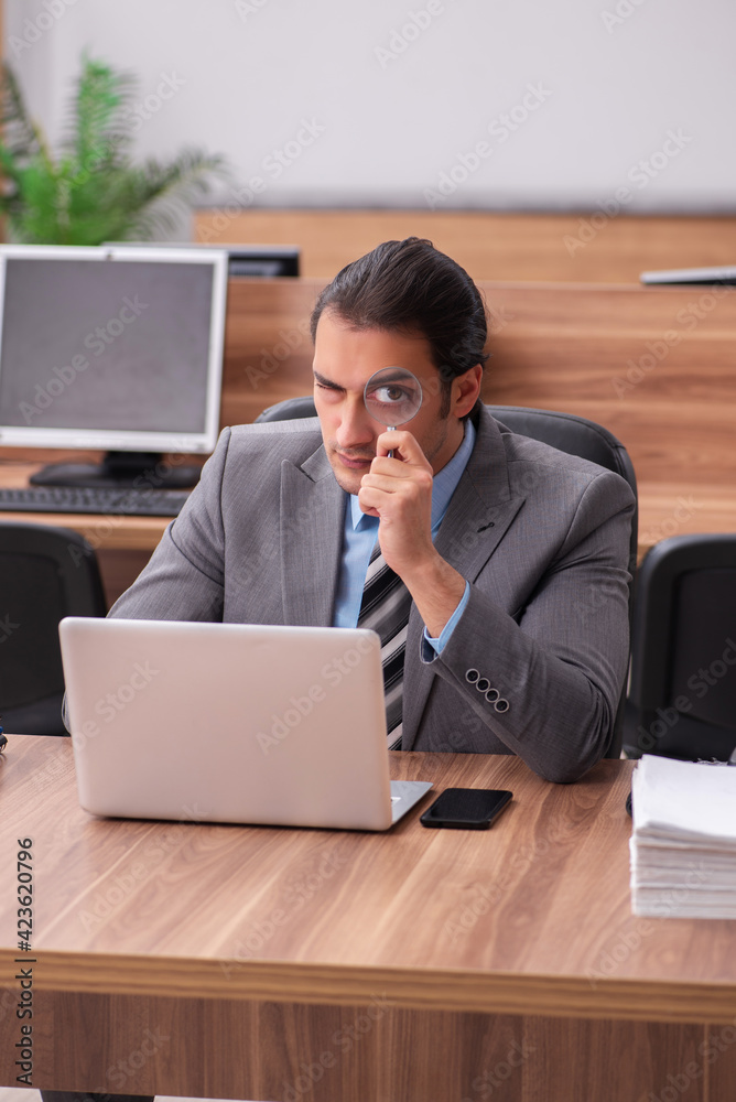 Young male employee working in the office Young male employee working in the office
