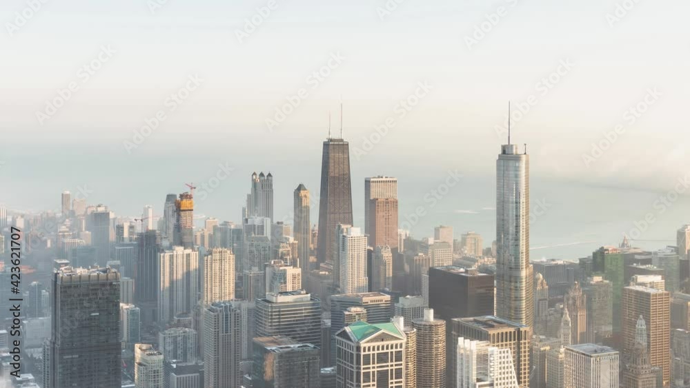Incredible panning out aerial skyline time lapse as patches of dense low fog makes its way into the heart of downtown Chicago and over Lake Michigan surrounding the highrise buildings at sunrise. Incredible panning out aerial skyline time lapse as patches of dense low fog makes its way into the heart of downtown Chicago and over Lake Michigan surrounding the highrise buildings at sunrise.