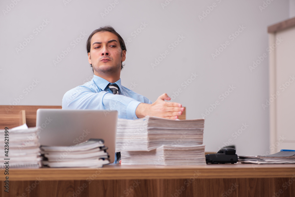 Young male employee unhappy with excessive work Young male employee unhappy with excessive work
