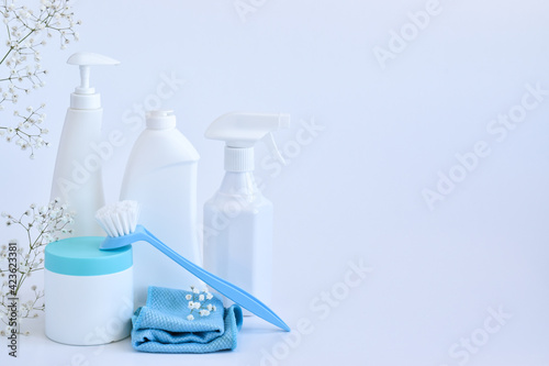 Cleaning products and sponges on a white background. Bottles of detergent and water. copy space