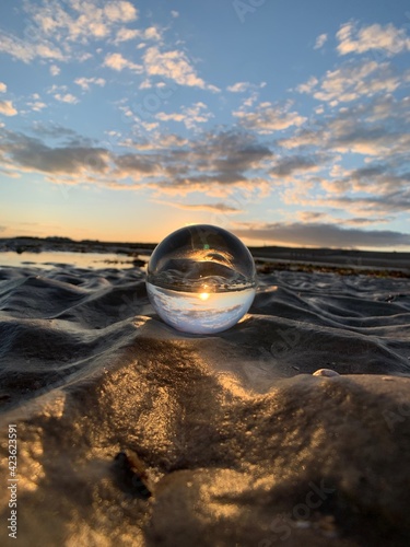 Glass crystal ball on the beach at sunset © ash.rosina