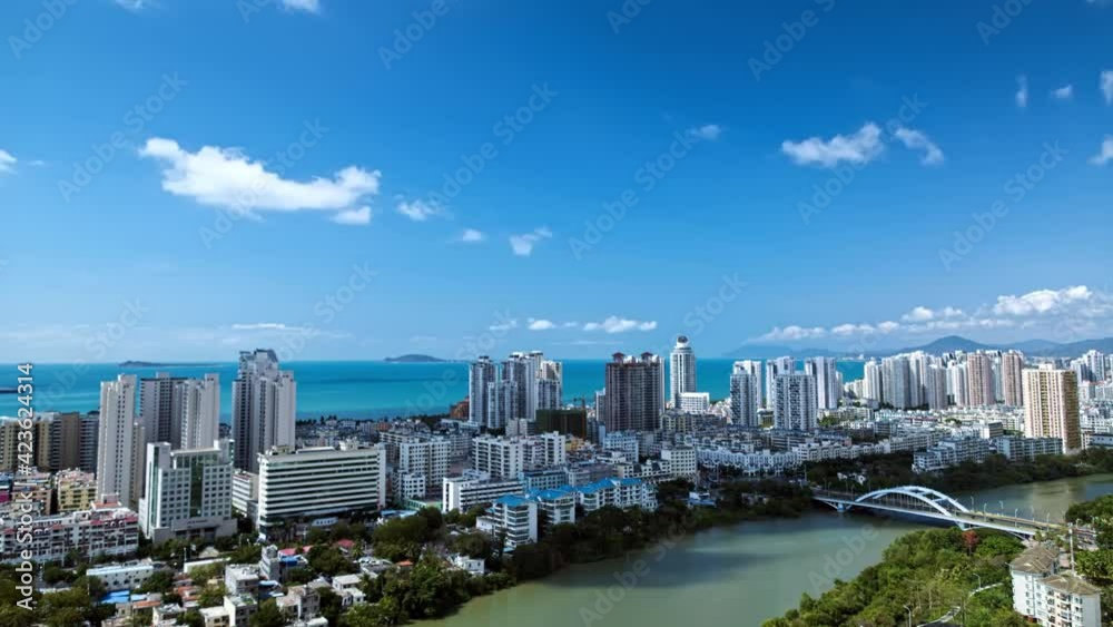 Time lapse video of moving clouds flowing over a seaside city Time lapse video of moving clouds flowing over a seaside city