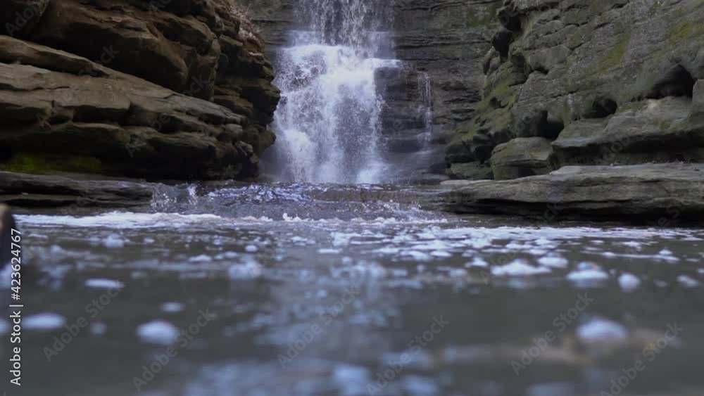 Low angle view of rocky valley waterfall in slow motion Low angle view of rocky valley waterfall in slow motion
