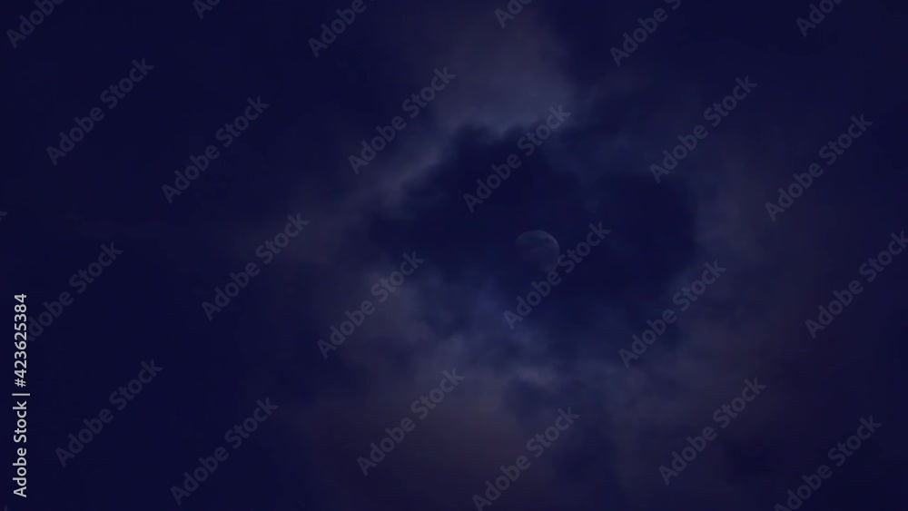 Close-up of floating clouds moving around the moon at night Close-up of floating clouds moving around the moon at night