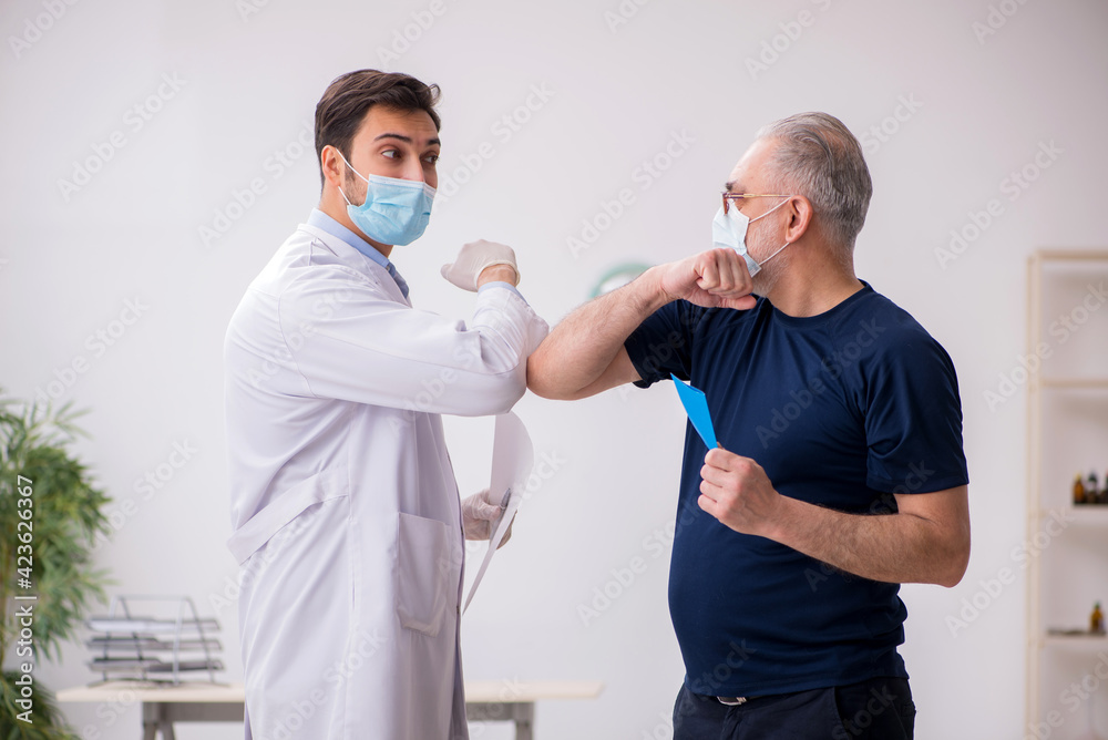 Old male patient visiting young male doctor in vaccination conce