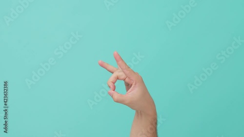 Closeup shot of human hand raising with finger flicking on blue screen