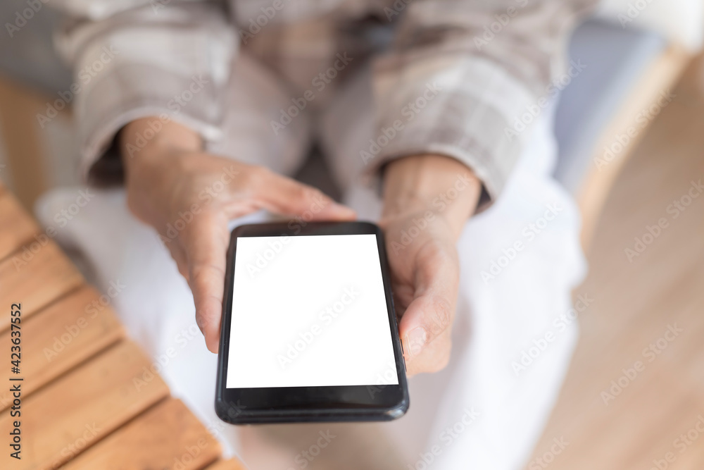 Close up women hands holding smartphone, mobile phone, cell phone with white blank screen for copy space. smart phone with blank screen on women hand soft focus selective phone. Technology lifestyle Close up women hands holding smartphone, mobile phone, cell phone with white blank screen for copy space. smart phone with blank screen on women hand soft focus selective phone. Technology lifestyle